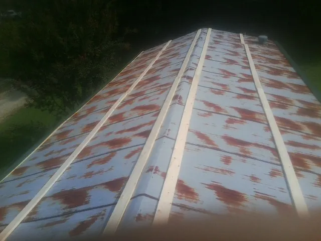 Rusted metal roof panels with new wood purlins before replacement — Storm Damage Roof Repair in Carpentersville by Roofing Brothers