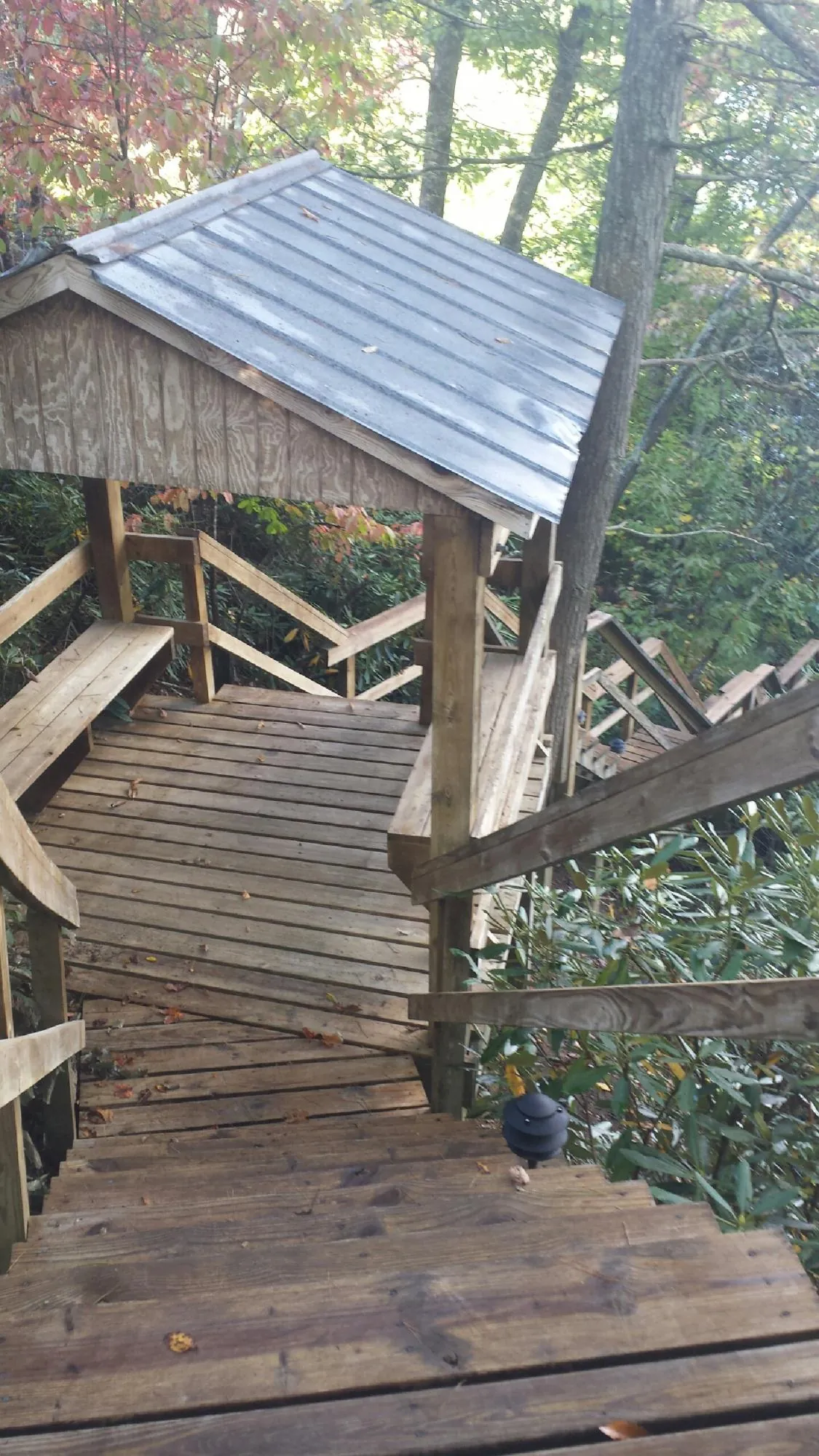 Metal roofed shelter over wooden steps on a wooded walkway — Skylight Repair & Installation work by our crew in Carpentersville