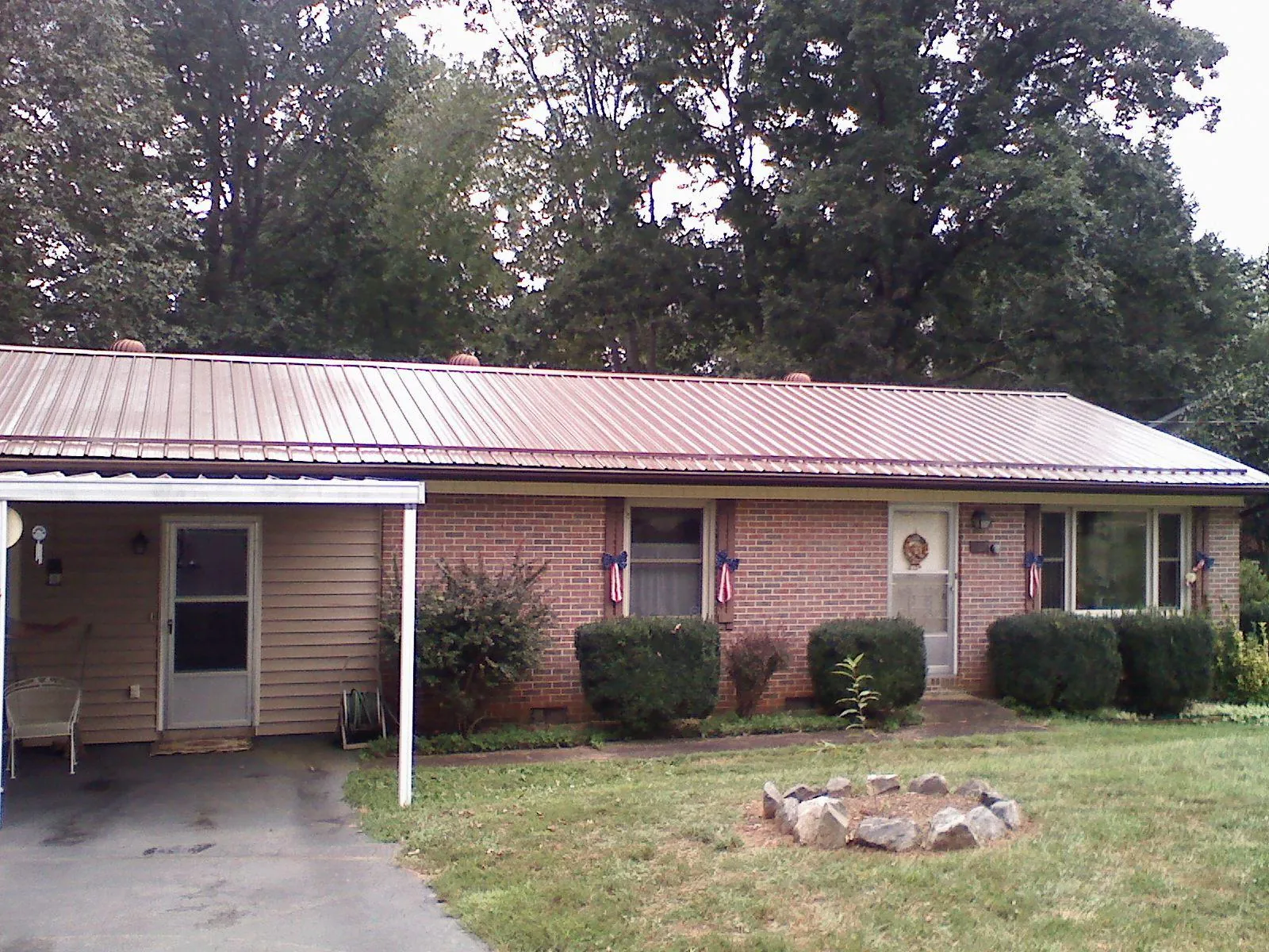 Bronze metal roof and carport on a brick ranch home — Roof Repair work by our crew in Carpentersville